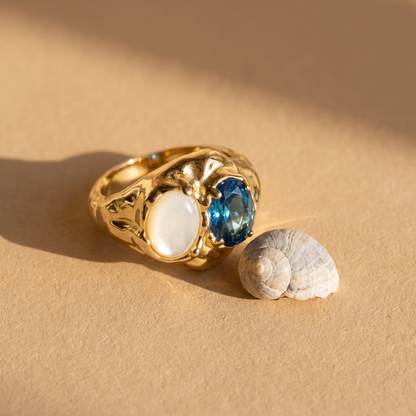 London Blue Topaz and Mother of Pearl Ring beside a seashell, 18K gold vermeil