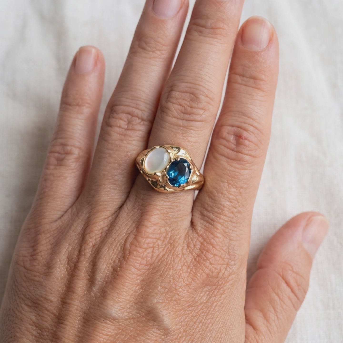 London Blue Topaz and Mother of Pearl Ring on the hand, true to size, light moving across the stones